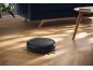 Robot aspirapolvere su pavimento in legno in un soggiorno