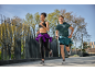 Due corridori in abbigliamento sportivo, che fanno jogging all'aperto in una giornata di sole.