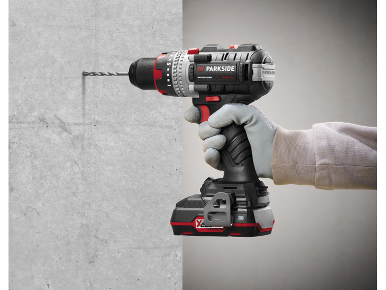 Trapano a batteria senza fili, che fora una parete di cemento.