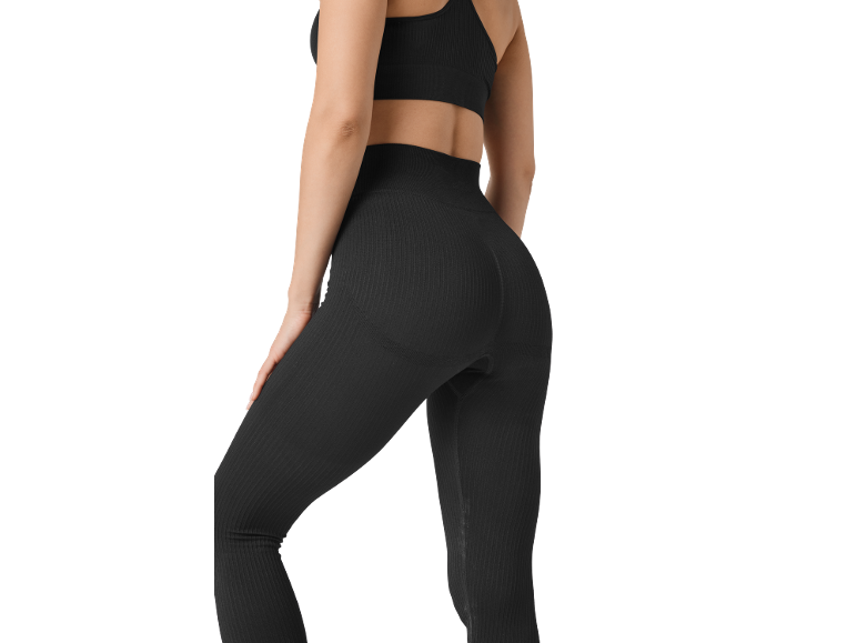 Donna in leggings e top sportivo neri a costine, vista posteriore.