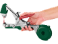Attrezzo manuale per legare piante in verde e rosso, tenuto da una mano.