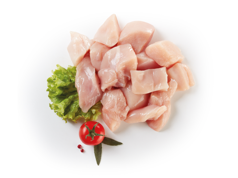 Pezzi di pollo crudo con lattuga, pomodoro ed erbe su sfondo bianco.