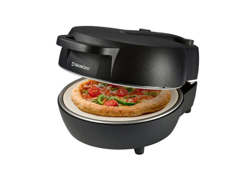 Forno per pizza nero con una pizza fresca all'interno, con pomodori e peperoni verdi.