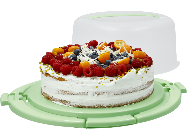 Torta di frutta con panna in un contenitore per torte verde chiaro.