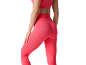 Donna in leggings e top sportivo a costine rosa corallo, vista posteriore.