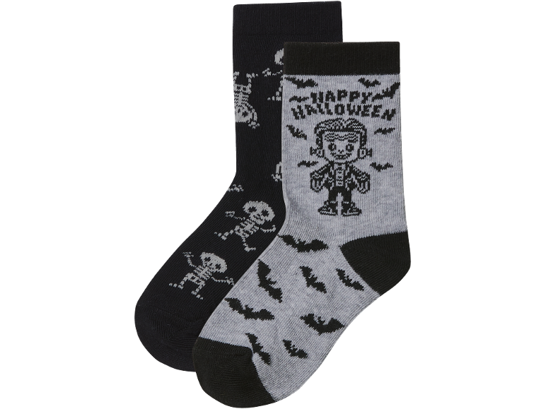 Un paio di calzini di Halloween: uno nero con scheletri, uno grigio con pipistrelli e Frankenstein con 'Happy Halloween'.