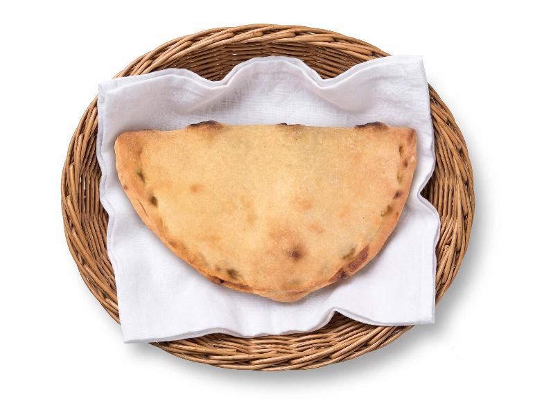 Calzone in un cesto di vimini con un tovagliolo bianco, visto dall'alto.