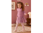 Bambina in felpa rosa, gonna in tulle e leggings, sorridente in una cameretta.