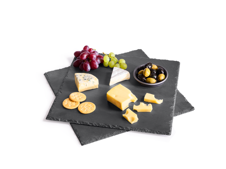 Tagliere di formaggi con vari formaggi, uva, olive e cracker su sfondo scuro.