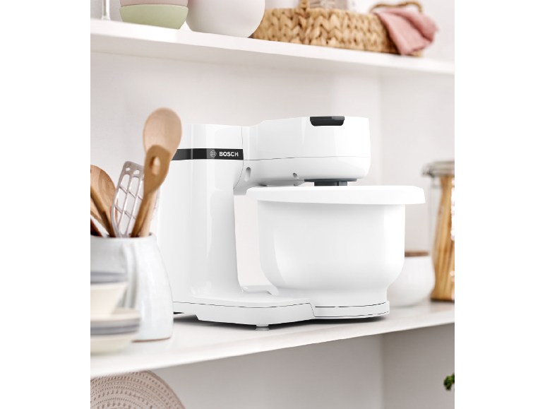 Robot da cucina bianco su uno scaffale della cucina con utensili in legno.