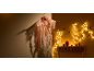 Decorazione di Halloween: fantasma con testa di zucca, luci a stringa e zucche su un tavolo.