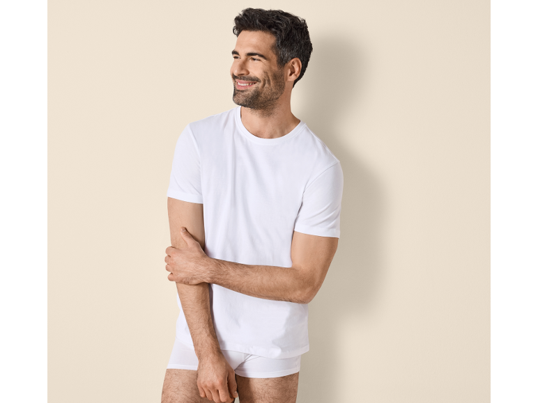 Uomo sorridente in maglietta bianca e slip.