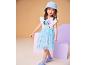 Bambina con cappello a secchiello blu, maglietta bianca con cane di paillettes e gonna di tulle blu.
