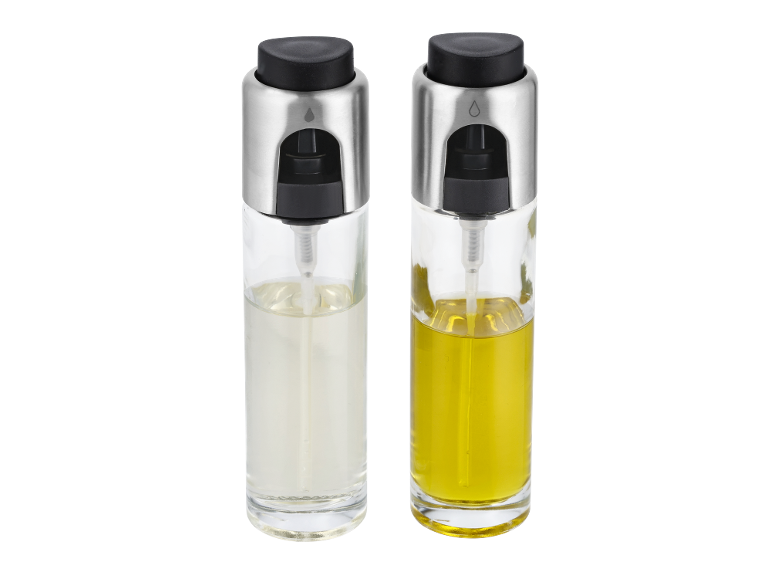 Due spruzzini per olio in vetro con tappi argento e neri, uno con liquido trasparente e uno giallo.