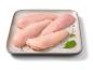 Filetti di petto di pollo crudi con salvia e grani di pepe su un piatto grigio.