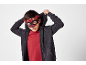 Bambino con felpa scura e maglietta rossa, indossa una maschera da pipistrello.