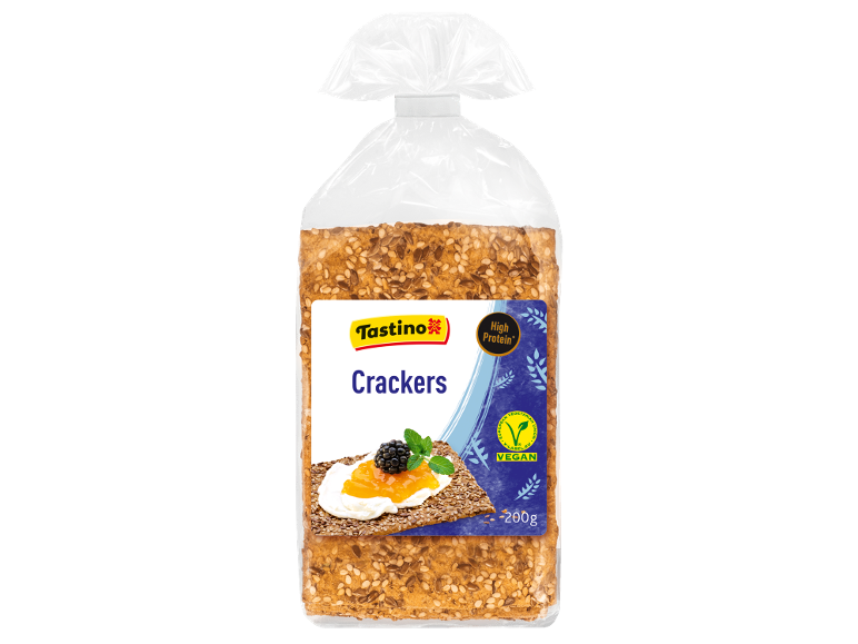 Confezione di cracker ad alto contenuto proteico con semi, con un cracker con marmellata e mora.