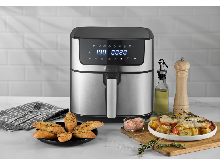 Friggitrice ad aria con display digitale, pane all'aglio e pesce con verdure.