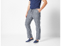 Uomo con maglietta blu, pantaloni di lino grigi con coulisse e scarpe slip-on blu.
