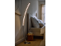 Lampada da terra a LED curva in una camera da letto moderna con letto e comodino.