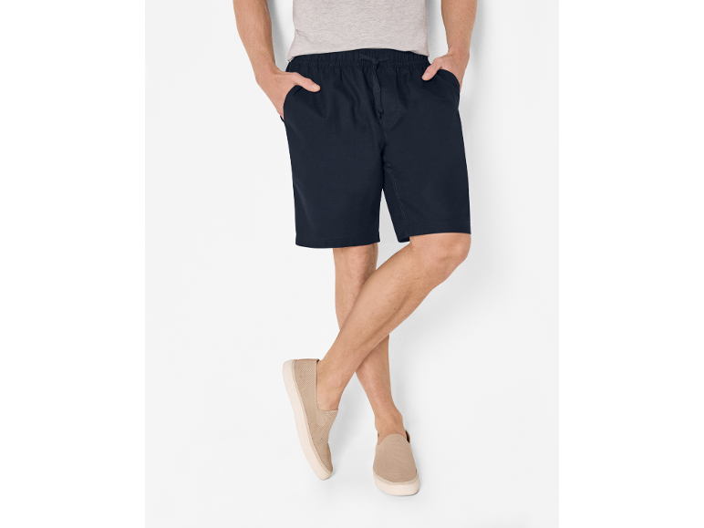 Pantaloncini da uomo blu navy con coulisse e scarpe slip-on beige.