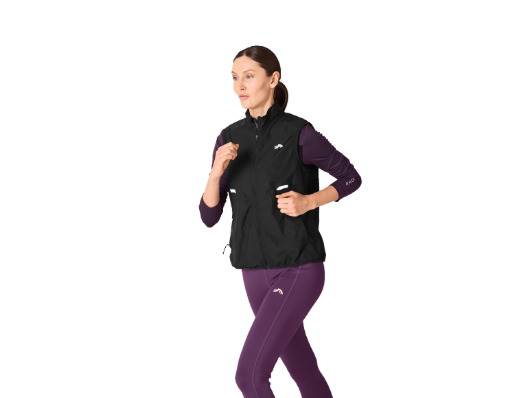 Donna con gilet nero e leggings viola da corsa.