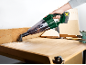 Aspirapolvere portatile che pulisce trucioli di legno da un banco da lavoro.