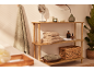 Scaffale in legno con asciugamani, prodotti da bagno e decorazioni in un bagno.