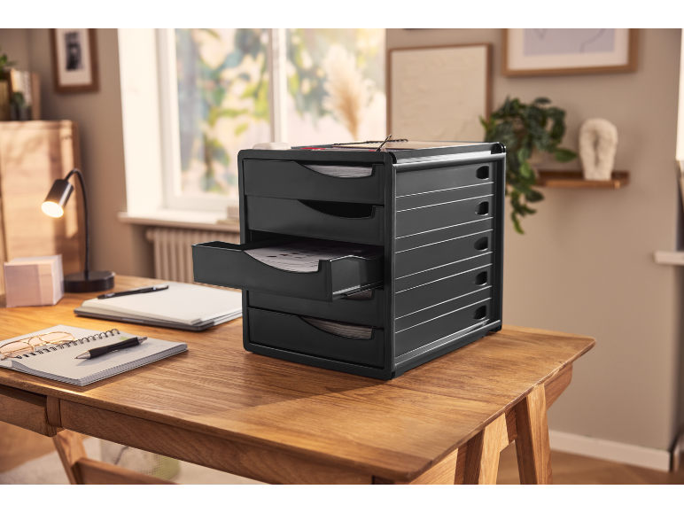 Organizzatore da scrivania nero con cassetti multipli su una scrivania in legno in un ufficio domestico.