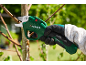 Forbici da potatura elettriche verdi che tagliano un ramo d'albero, tenute da una mano guantata.