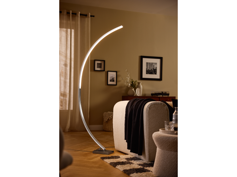 Lampada da terra LED curva in un soggiorno moderno con divano e decorazioni.