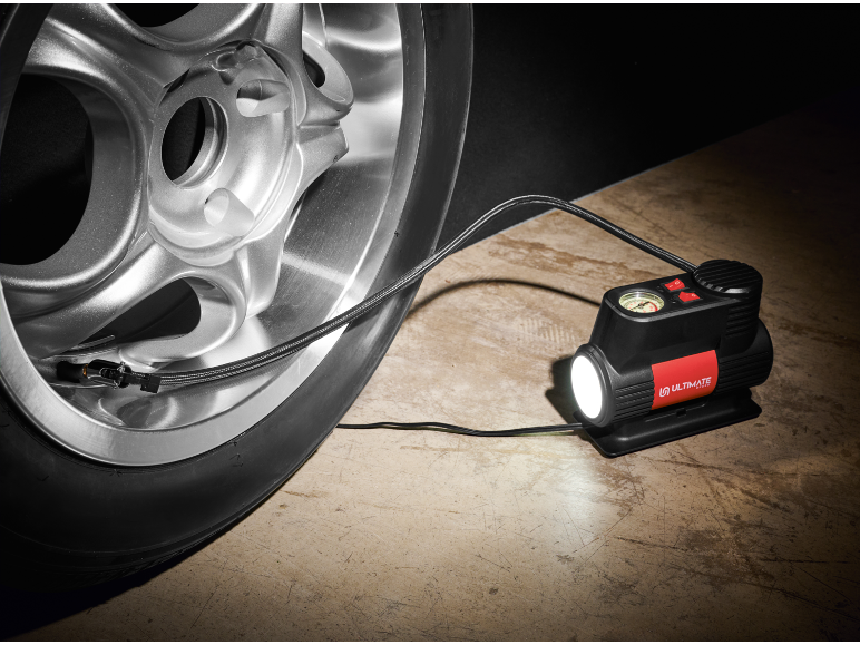 Gonfiatore portatile per pneumatici con luce integrata collegato a un pneumatico d'auto.