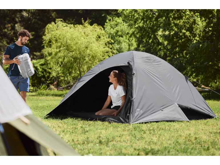 Uomo e donna in tenda nella natura, si preparano per il campeggio.