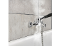 Pulitore a vapore che pulisce un rubinetto del bagno e piastrelle sopra una vasca da bagno.