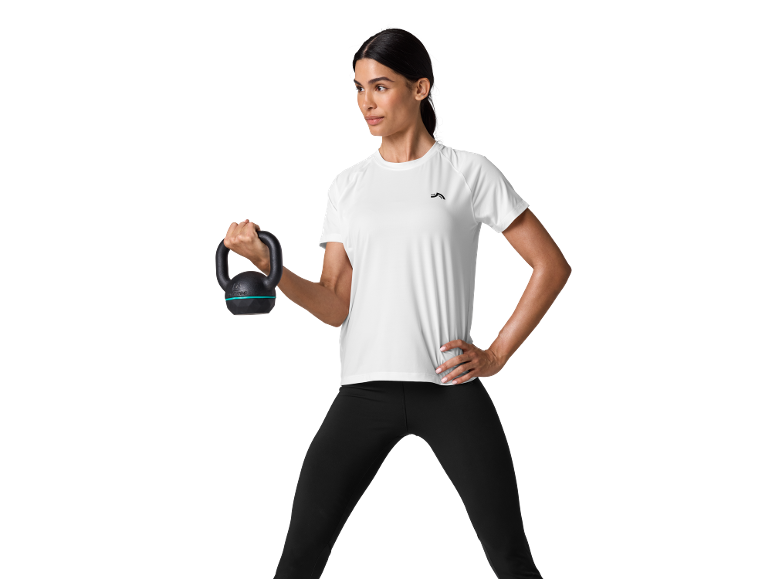 Donna in maglietta sportiva bianca e leggings neri, tiene un kettlebell.