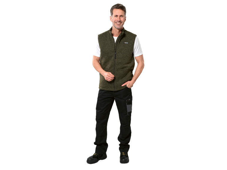 Uomo con gilet verde, maglietta bianca e pantaloni da lavoro neri con tasche porta attrezzi.