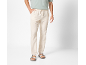Uomo con maglietta verde chiaro, pantaloni di lino beige e sandali chiari.