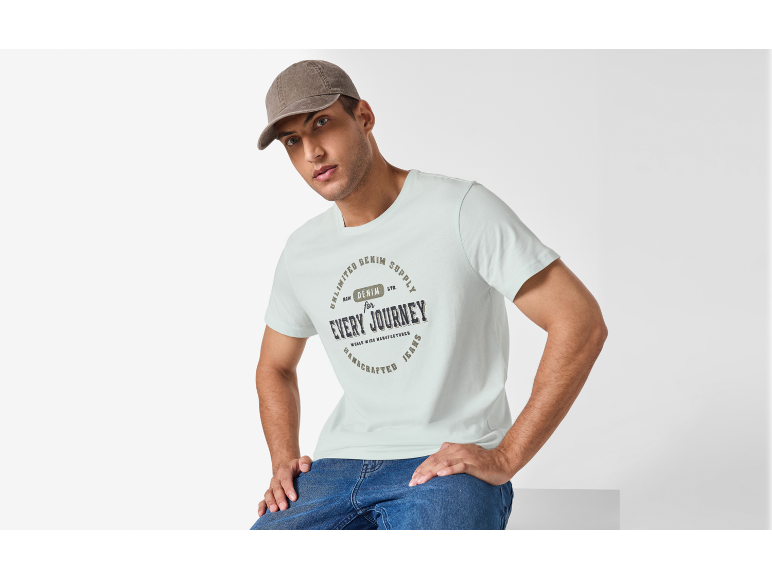 Uomo in maglietta bianca e cappellino, con la scritta 'EVERY JOURNEY'.