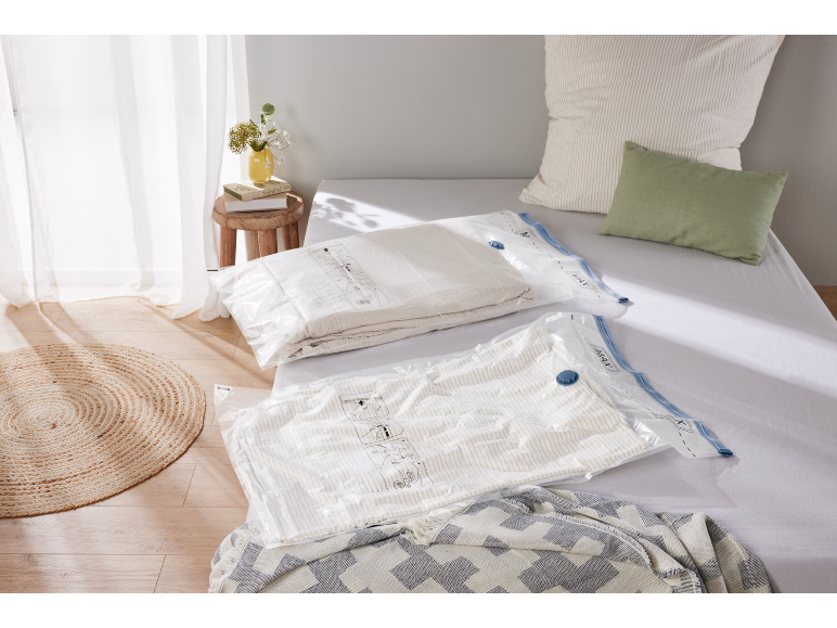 Sacchi sottovuoto con biancheria da letto su un letto in una camera da letto luminosa.