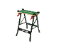 Banco da lavoro con superficie a fantasia verde e maniglie rosse.