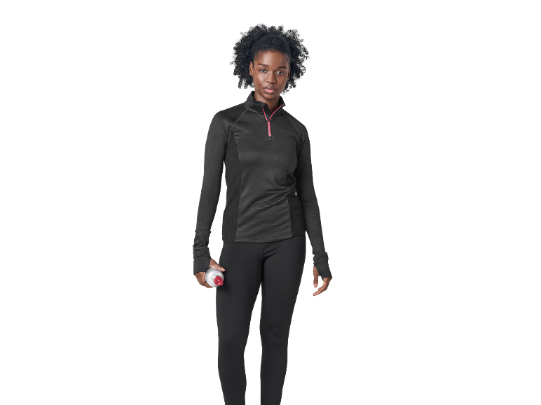 Donna in abbigliamento sportivo nero con cerniera rosa, tiene una borraccia.