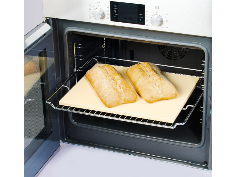 Pane appena sfornato in un forno con pietra refrattaria