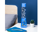 Lampada decorativa blu con disegni animati, accanto a un letto e una pianta.