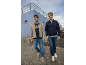 Due uomini in giacche casual, jeans e magliette all'aperto.