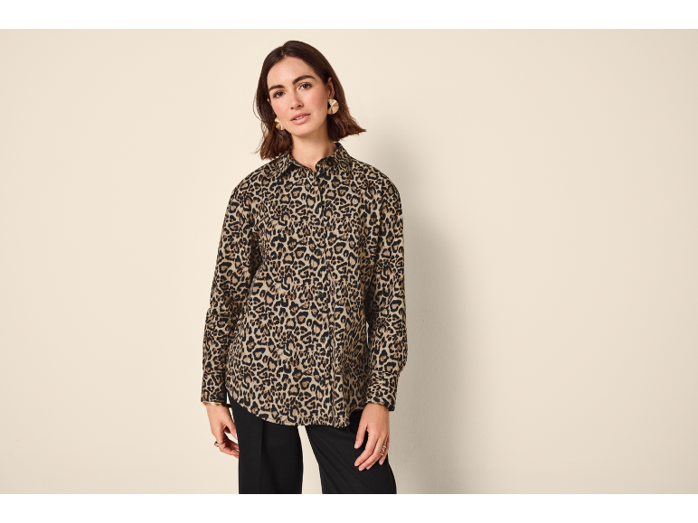 Donna con camicia leopardata e pantaloni neri.