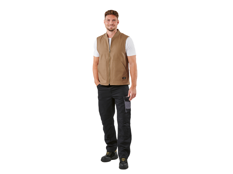 Uomo con gilet marrone, maglietta bianca e pantaloni da lavoro neri con scarpe.