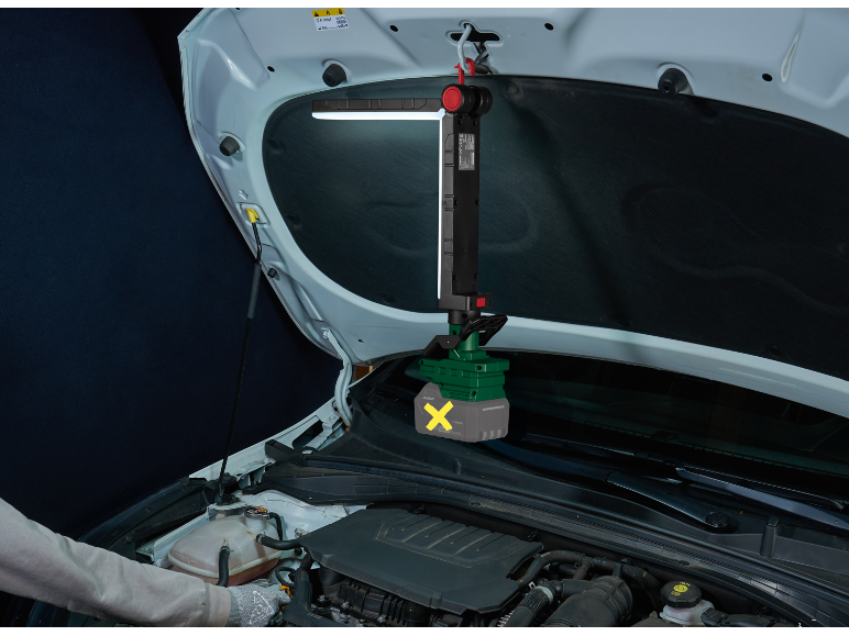 Lampada da lavoro a LED appesa sotto il cofano di un'auto, che illumina il motore mentre una persona lo controlla.