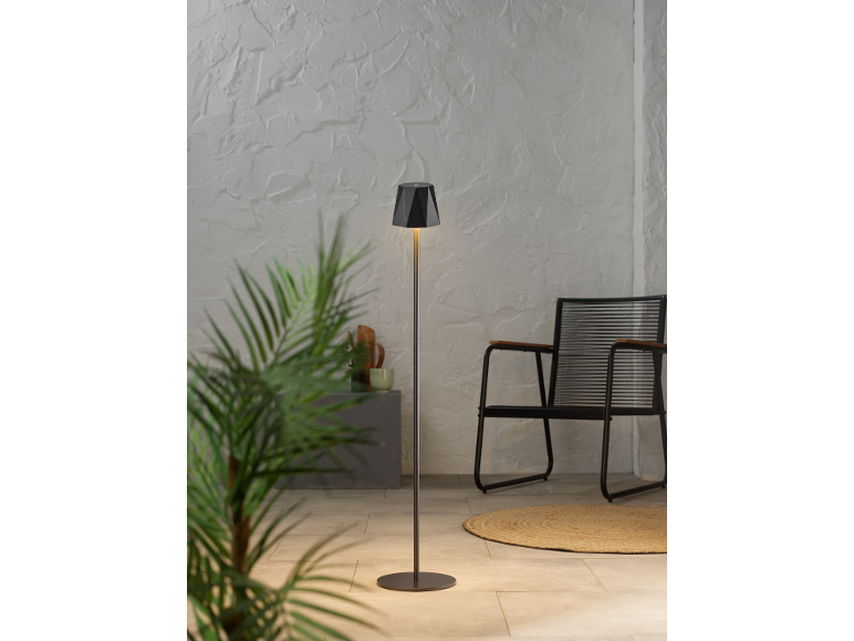 Lampada da terra con paralume geometrico in un interno moderno con pianta e sedia