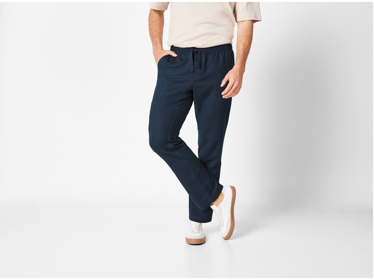 Uomo con pantaloni jogger blu navy e maglietta beige.