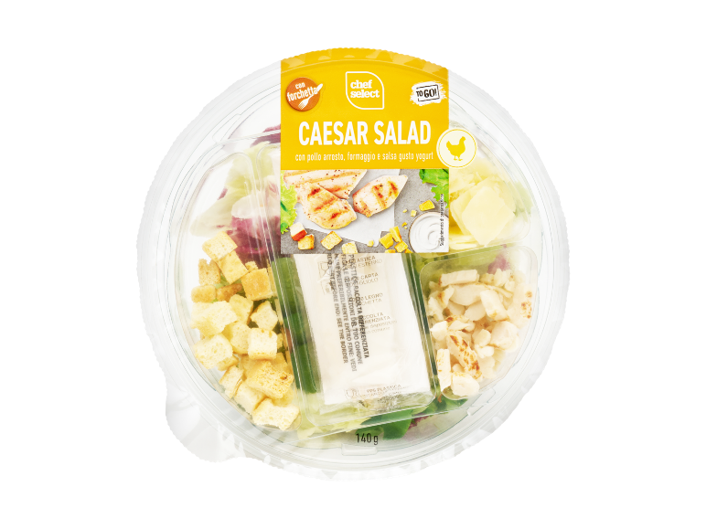 Insalata Caesar con pollo arrosto, formaggio e salsa allo yogurt in un contenitore di plastica trasparente.